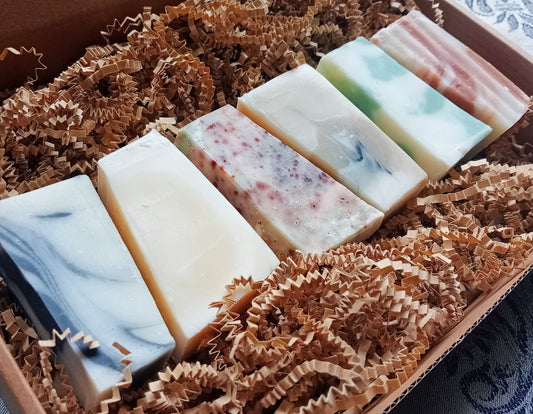 Set of six handmade soap bars in a decorative box with brown crinkle paper
